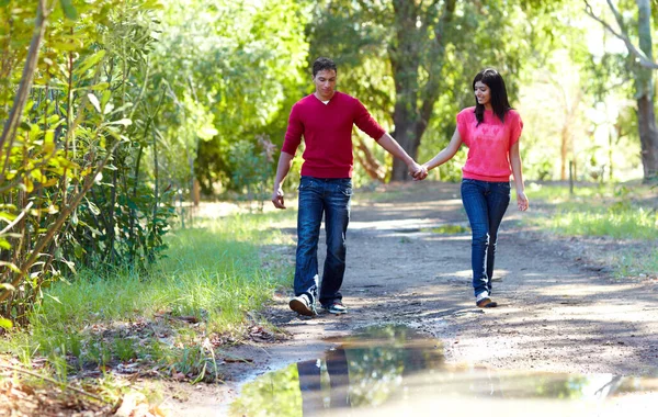 Dando un paseo romántico. Foto de una pareja joven y cariñosa que va a dar un paseo al aire libre. — Foto de Stock