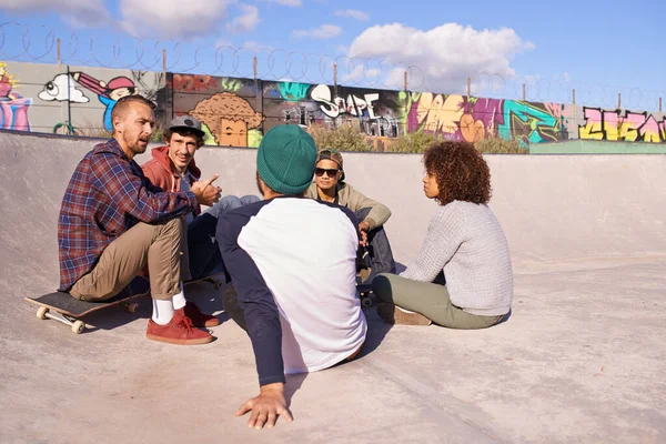 Het delen van hun gemeenschappelijke belangen. Een foto van een groep vrienden die rondhangen in de zon in een skatepark.. — Stockfoto