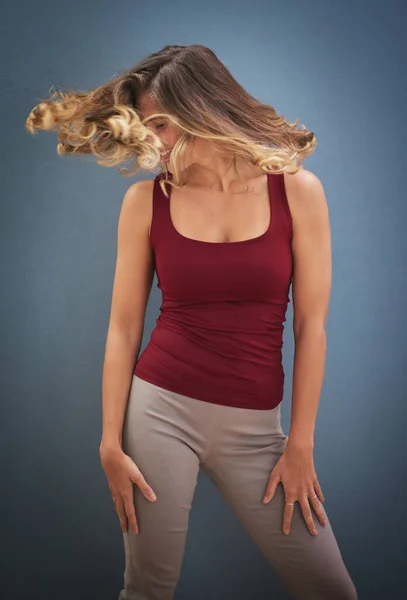 Lascia che tutto esca allo scoperto. Girato di una giovane donna che roteava i capelli su uno sfondo grigio. — Foto Stock
