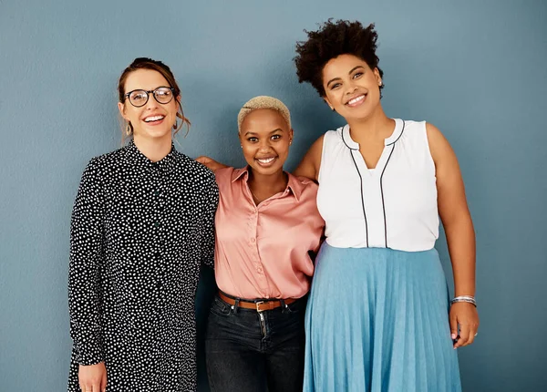 Étaient une équipe si heureuse. Portrait studio d'un groupe de jeunes femmes d'affaires séduisantes souriant tout en se tenant ensemble sur un fond gris. — Photo