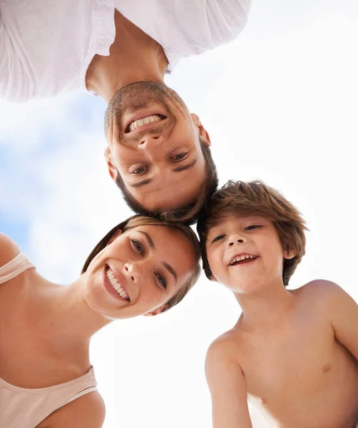 Uma família feliz. Visão de baixo ângulo de uma família feliz de pé com as cabeças juntas. — Fotografia de Stock