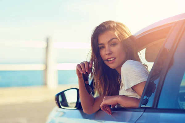 Es ist der beste Ort, um zu sein. Porträt einer jungen Frau, die sich aus dem Fenster ihres Autos lehnt. — Stockfoto