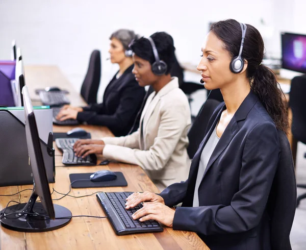 Ze hebben altijd een goede dienst bewezen. Gesneden foto van drie vrouwelijke call center vertegenwoordigers met een headset.. — Stockfoto