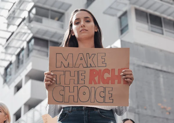 Kendin için doğru seçimi yap. Arkaplanda diğer göstericilerle birlikte covid 19 aşısını protesto eden bir tabela tutan çekici bir genç kadının kesilmiş portresi.. — Stok fotoğraf