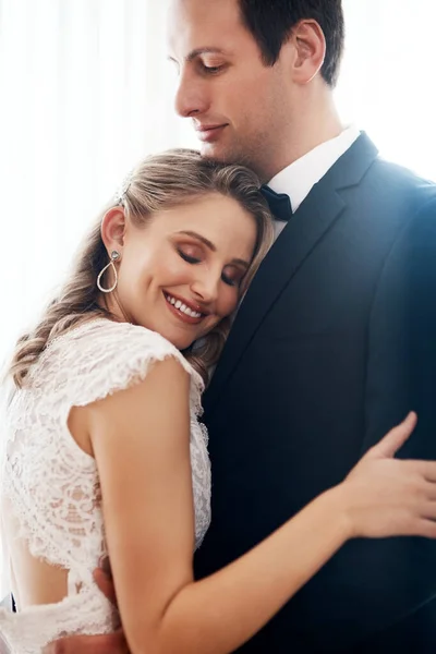 Puseste os braços à minha volta e eu estava em casa. Tiro recortado de um jovem casal feliz em pé dentro de casa e abraçando uns aos outros carinhosamente depois de seu casamento. — Fotografia de Stock