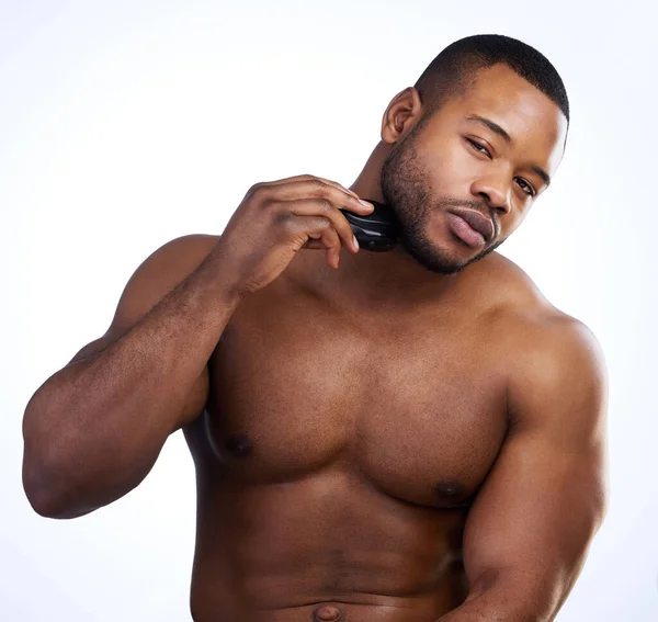 Estou a aparar um pouco a barba. Estúdio retrato de um belo jovem barbeando contra um fundo branco. — Fotografia de Stock