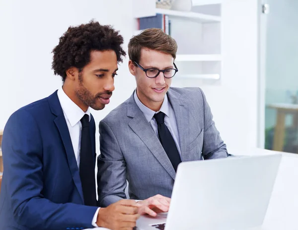 A juntar as cabeças para uma solução. Tiro de dois colegas do sexo masculino trabalhando juntos em um laptop. — Fotografia de Stock