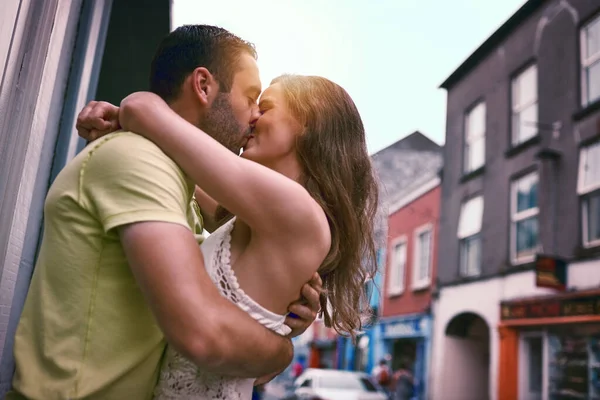 Liebe ist ein lebenslanges Abenteuer. Aufnahme eines liebevollen jungen Paares, das sich küsst, während es eine fremde Stadt erkundet. — Stockfoto