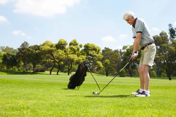 Die richtige Haltung finden... Senior-Mann macht sich bereit, auf dem Golfplatz zu schwingen. — Stockfoto