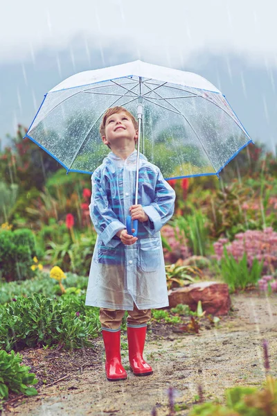 비의 근원을 찾는 중이야. 밖에서 비를맞고 있는 어린 소년의 전체 사진. — 스톡 사진