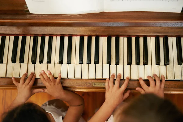 Παίζω ντουέτο. Άποψη υψηλής γωνίας δύο μικρών κοριτσιών να παίζουν ντουέτο στο πιάνο. — Φωτογραφία Αρχείου
