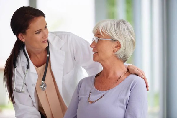 Dokters moeten ook goed luisteren. Shot van jonge arts controleren op haar senior patiënt. — Stockfoto