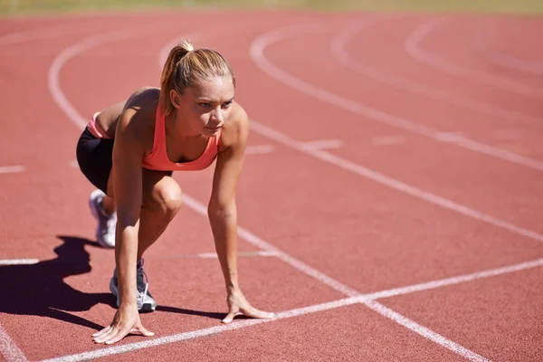 Listos para una carrera. Tiro de un joven corredor atractivo en la pista. — Foto de Stock