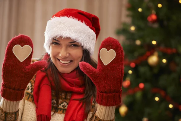 Kerstliefde. Portret van een aantrekkelijke jonge vrouw die je haar kersthandschoenen laat zien. — Stockfoto