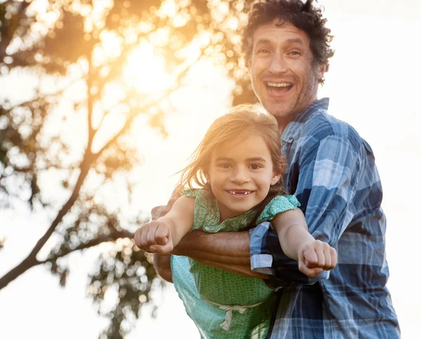 Moedig haar moed aan. Portret van een gelukkige vader speels dragen van zijn dochter tijdens een leuke dag buiten. — Stockfoto