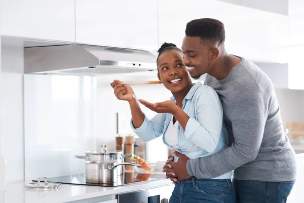 Ya sabes que todo lo que haces es delicioso. Disparo de un hombre abrazando a su esposa por detrás mientras ella está ocupada cocinando. — Foto de Stock