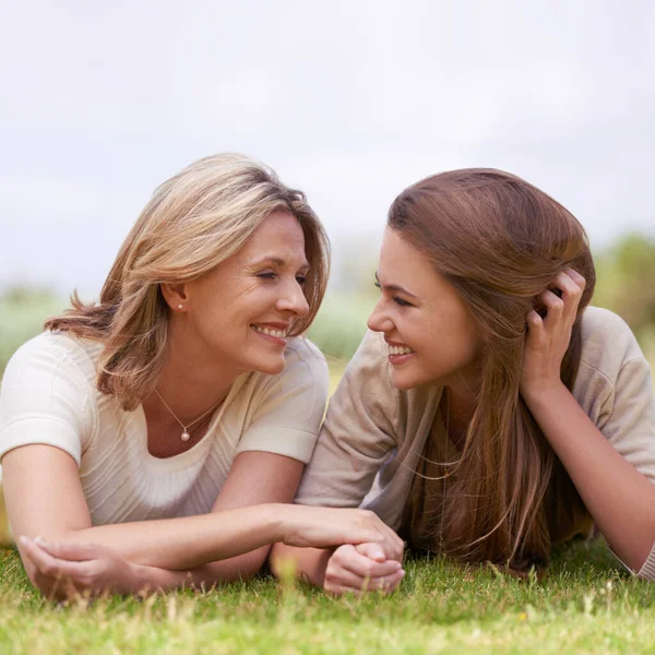 Speciale tijd met haar dochter. Een liefhebbende moeder en dochter liggen zij aan zij op het gras. — Stockfoto