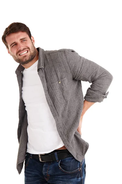 Dont let back pain get the better of you. Studio shot of a young man grimacing in pain while holding his back. — Stock Photo, Image