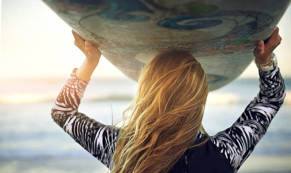 På väg ut i havet. Rearview skott av en oigenkännlig ung kvinnlig surfare står med sin surfbräda tittar över havet. — Stockfoto