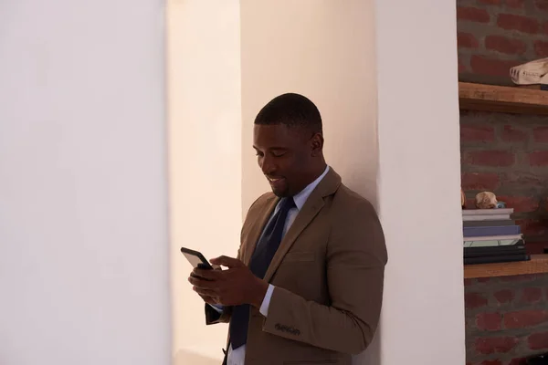 새로운 고객들에게 문자를 보내는 거야. 젊은 사업가 가 사무실에서 핸드폰을 사용하는 사진.. — 스톡 사진