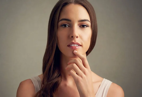 Besinnliche Schönheit. Studioporträt einer attraktiven jungen Frau vor braunem Hintergrund. — Stockfoto