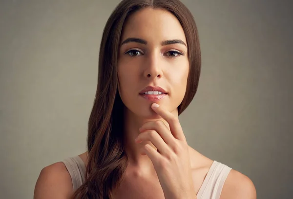 Bellezza contemplativa. Studio ritratto di una giovane donna attraente in piedi su uno sfondo marrone. — Foto Stock