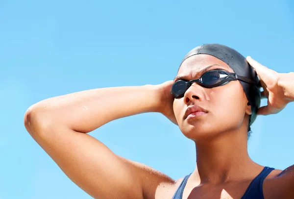 Вирощування мислення переможців. Вирішена молода жінка плаває, регулюючи її окуляри для плавання . — стокове фото