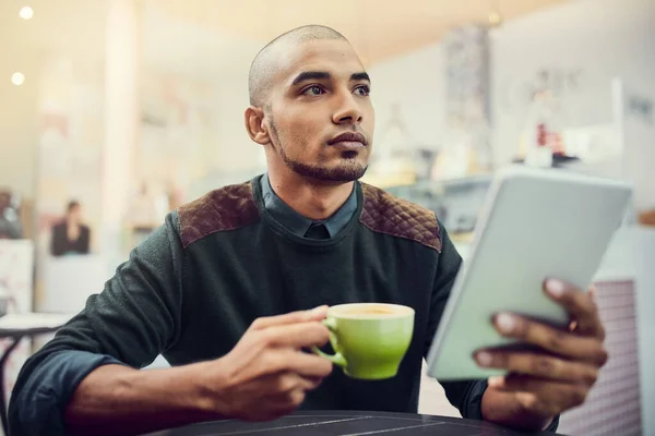 Creo que este café merece una alta calificación. Fotografía de un joven sentado en un café con su tableta digital. —  Fotos de Stock