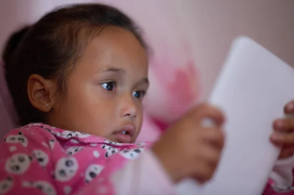 Ze is een nieuwsgierig kleintje. Opname van een klein meisje in bed met behulp van een digitale tablet. — Stockfoto