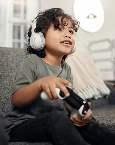 Én nyerem ezt a kört. Egy cuki kisfiúról készült felvétel, aki fejhallgatót visel, miközben otthon videojátékozik.. — Stock Fotó