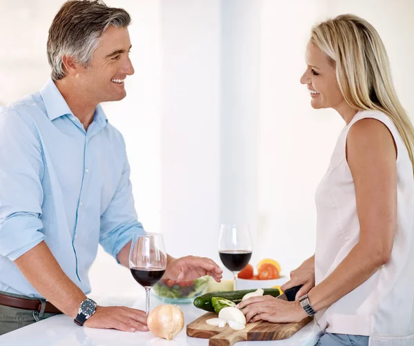 料理と結合。一緒に夕食を作りながらワインを楽しみながら話している成熟したカップルの作物のショット. — ストック写真