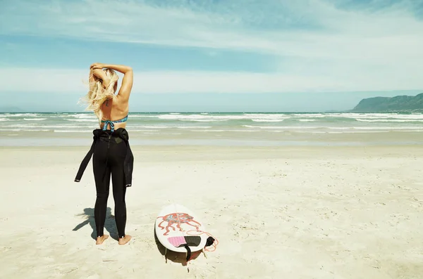 海と一つになる準備をする。海に入る前にストレッチ若いサーファーの女の子. — ストック写真