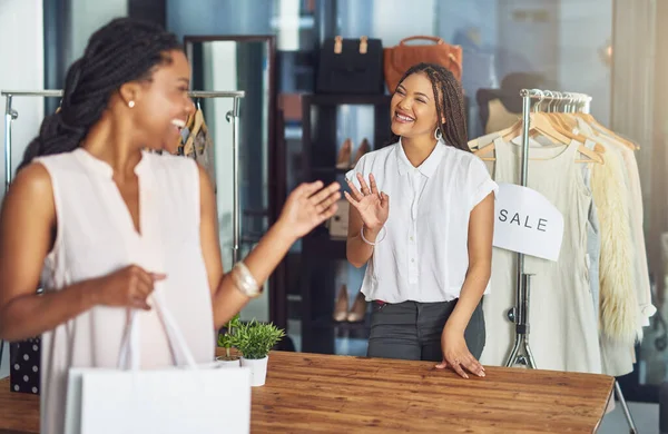 Thank you for shopping with us. Cropped shot of a cashier and a customer waving goodbye to each other.