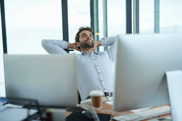 El éxito se siente genial. Fotografía de un joven empresario corporativo tomando un descanso en un escritorio de la oficina. —  Fotos de Stock