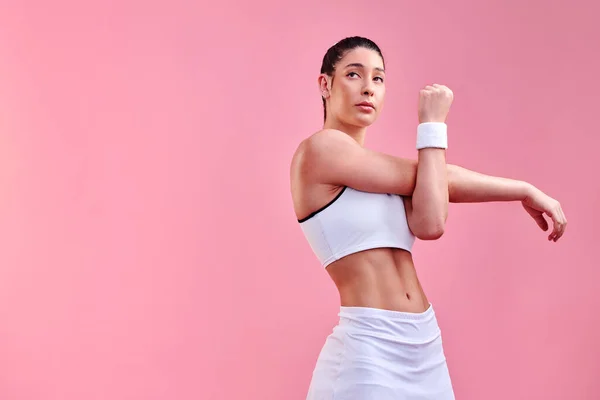 Hacer excusas no te llevará a ninguna parte. Estudio de una joven deportista estirando los brazos sobre un fondo rosa. —  Fotos de Stock