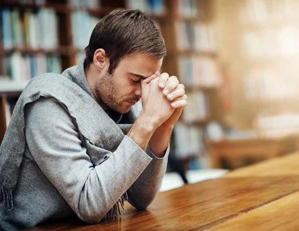 Buscando ajuda de cima. Tiro cortado de um jovem bonito orando por ajuda com seus próximos exames universitários. — Fotografia de Stock