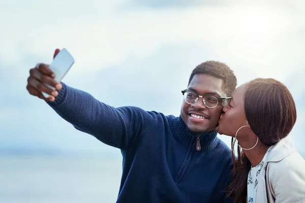 Eles estão loucamente apaixonados. Tiro de um jovem casal afetuoso tirando selfies juntos ao ar livre. — Fotografia de Stock
