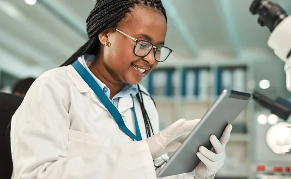 Teilen Sie die Nachricht von ihrer neuesten Entdeckung. Aufnahme eines jungen Wissenschaftlers mit einem digitalen Tablet im Labor. — Stockfoto