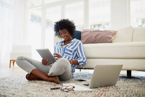 Ihr Blog hat sie zu einer Online-Sensation gemacht. Aufnahme einer jungen Frau, die zu Hause an ihrem digitalen Tablet und Laptop arbeitet. — Stockfoto