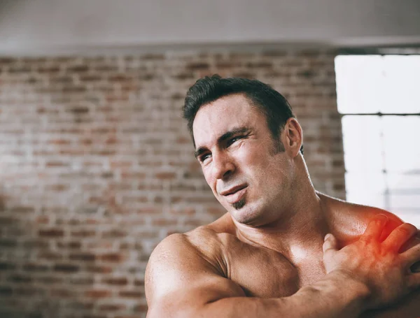 No te apresures demasiado. Foto de un hombre que sufre de una lesión en el hombro en el gimnasio. — Foto de Stock