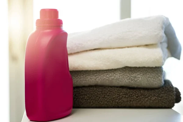 Joka ei rakasta puhtaita pyyhkeitä. Laukaus pesuainetta ja kasa viikattuja pyyhkeitä kotona.. — kuvapankkivalokuva