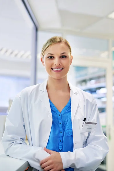 Έχει τις απαντήσεις στις ερωτήσεις ευεξίας σου. Πορτρέτο μιας χαρούμενης νεαρής γυναίκας που εργάζεται σε φαρμακείο. — Φωτογραφία Αρχείου