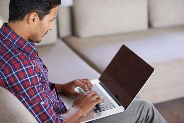 Hes got some great ideas for the blog. Shot of a handsome young man relaxing at home. Stock Picture