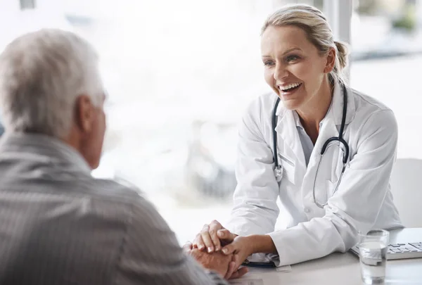 Me alegra ver que estás en tan buena salud. Fotografía recortada de una doctora madura que trabaja con un paciente masculino mayor en su consultorio en el hospital. — Foto de Stock