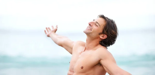 В этом вся суть жизни. Снимок красивого молодого человека, наслаждающегося прекрасным днем на пляже. — стоковое фото