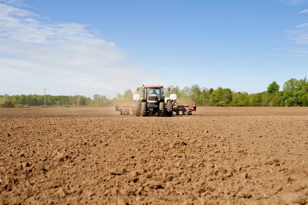 Seminare la terra. Girato di un trattore che semina un grande campo arato in una fattoria. — Foto Stock