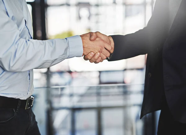 É um acordo. Tiro recortado de dois empresários irreconhecíveis apertando as mãos em um escritório. — Fotografia de Stock