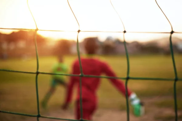 Život je jako fotbal - potřebuješ góly. Rozostřený záběr mladých chlapců hrajících fotbal na sportovním hřišti. — Stock fotografie