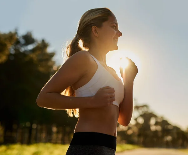 Zbav se stresu. Shot of a happy young woman out for a run in nature. — Stock fotografie