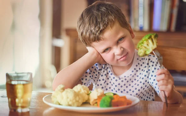 Nem pensar que estou a comer isto. Retrato de um menino nojento se recusando a comer seus vegetais na mesa de jantar. — Fotografia de Stock